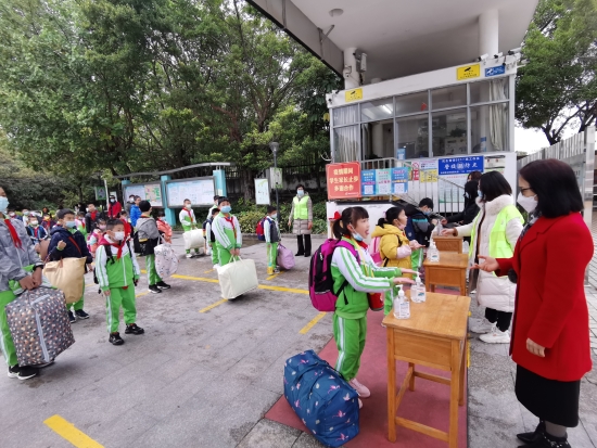 已處理10  沙坪六小的同學們保持1米線距離在校門口進行手部消毒,，有序進校園.jpg